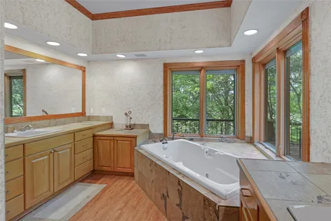 a spacious bathroom with a tub sink and mirror
