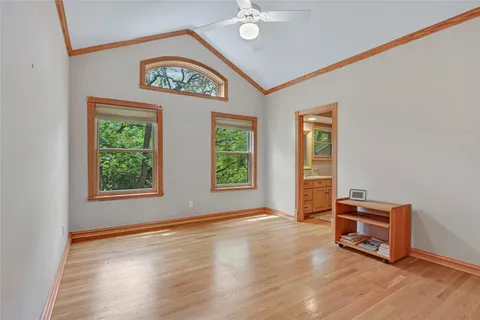 a bedroom with a bed and large windows
