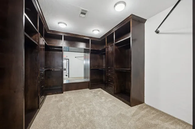 a spacious bedroom with a bed and a chandelier