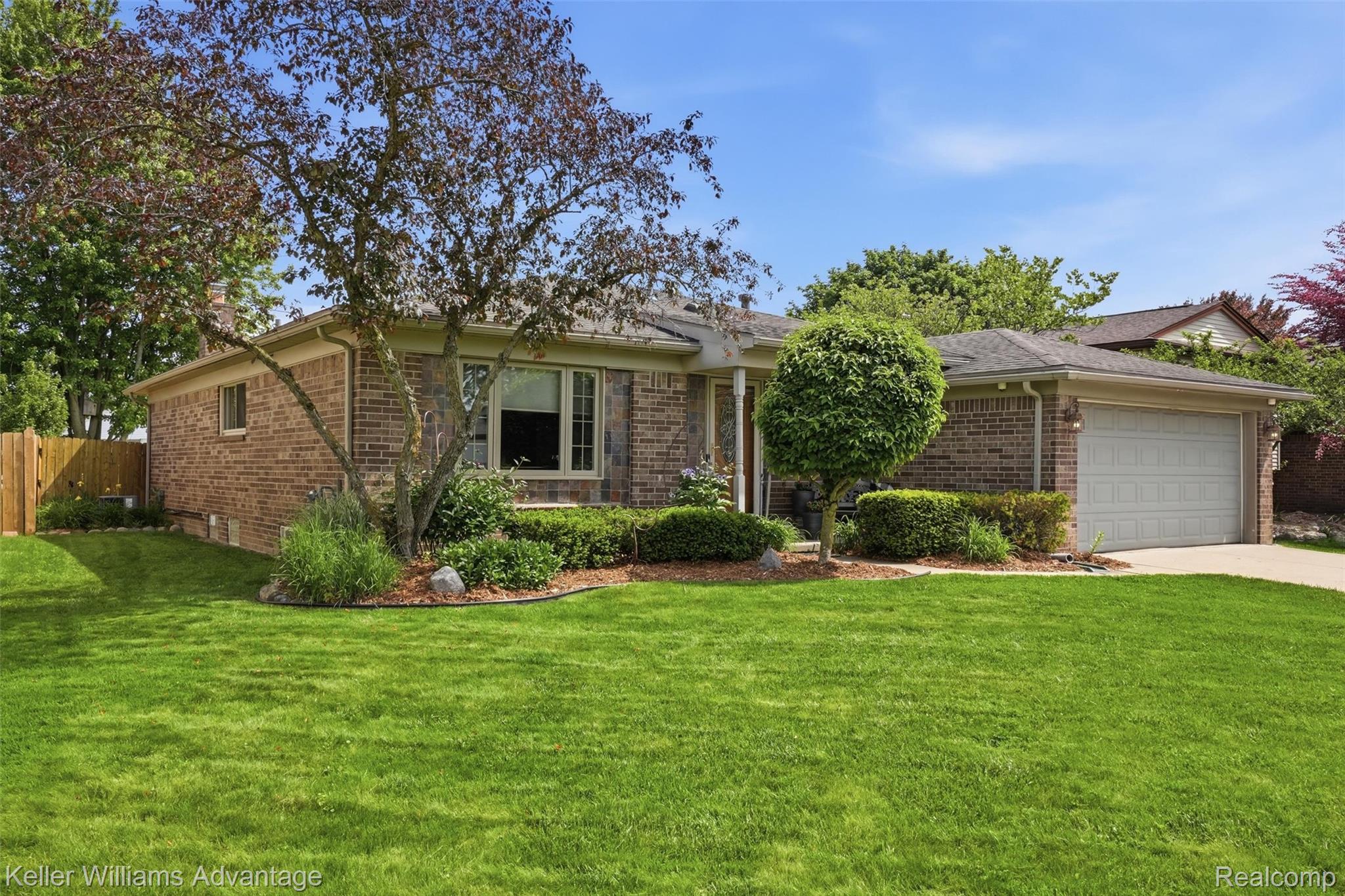 42505 Saltz Road Canton, MI 48187 - Photo 2 of 52 View of front of house featuring a garage, brick siding, and driveway
