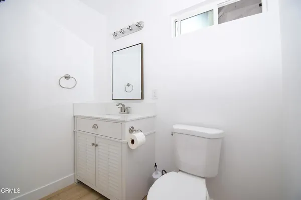 a bathroom with a toilet a sink and mirror