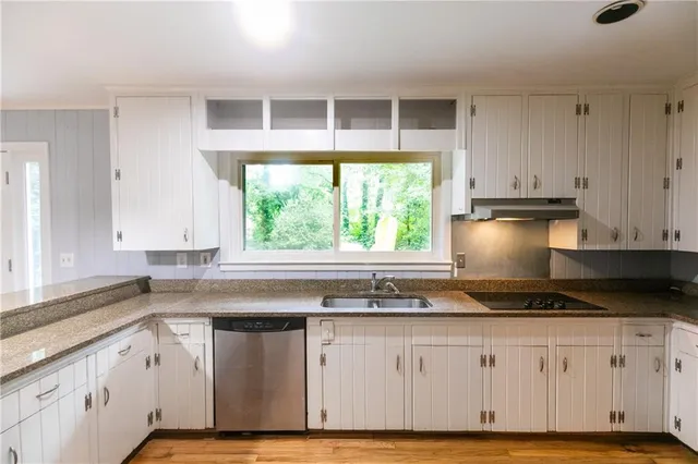 a view of a room with wooden floor and a ceiling fan