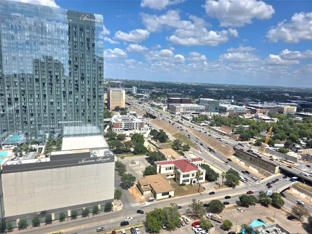 a living room with furniture a rug kitchen view and a table