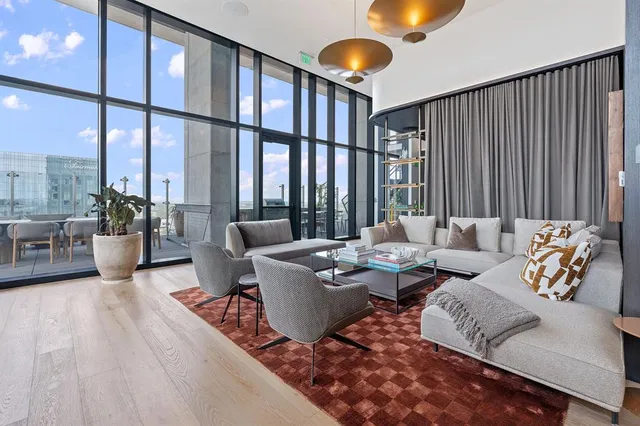 a view of a patio with table and chairs potted plants and floor to ceiling window
