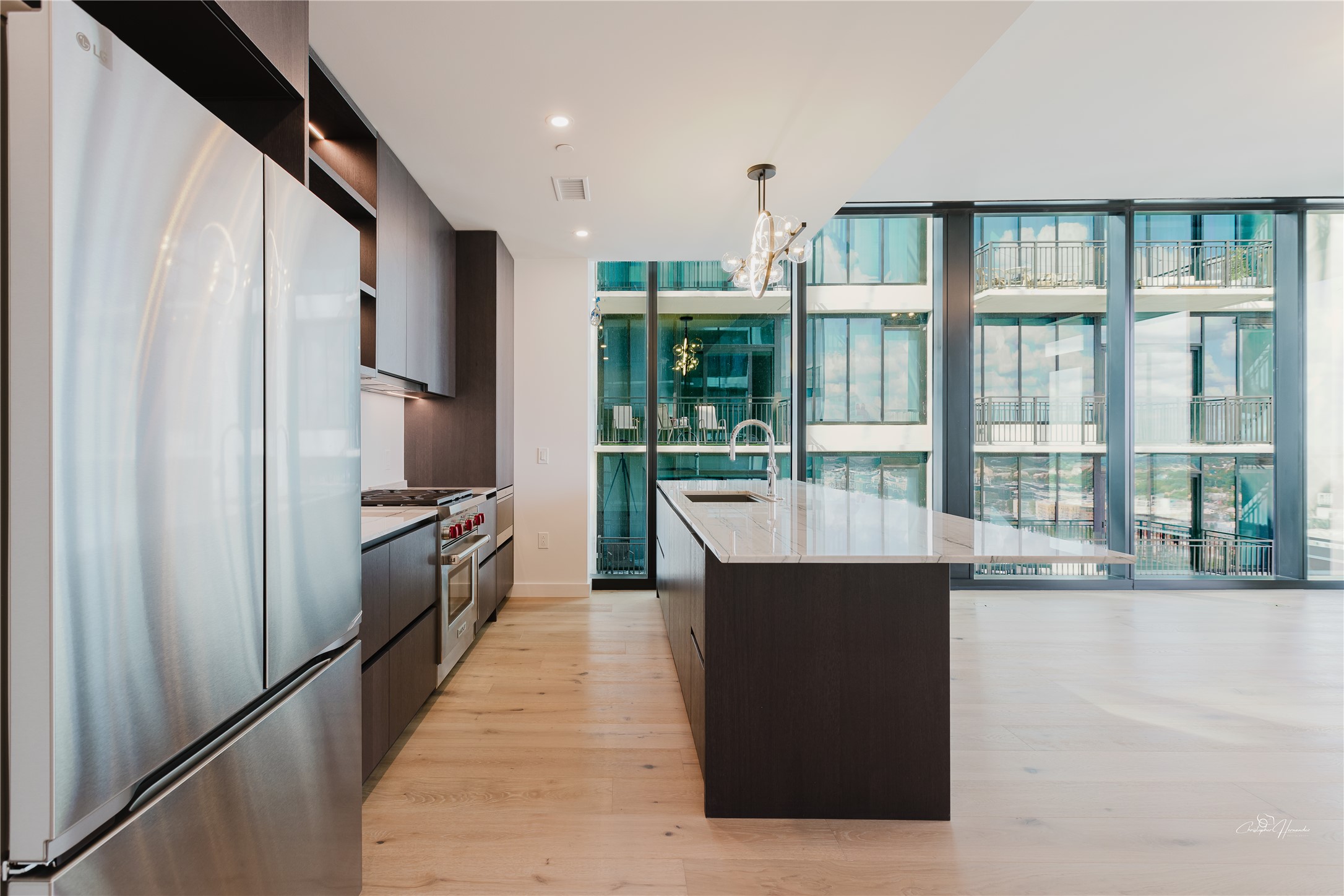 610 Davis Street, Unit 2608 Austin, TX 78701 - Photo 12 of 39 a kitchen with stainless steel appliances kitchen island granite countertop a refrigerator and a sink