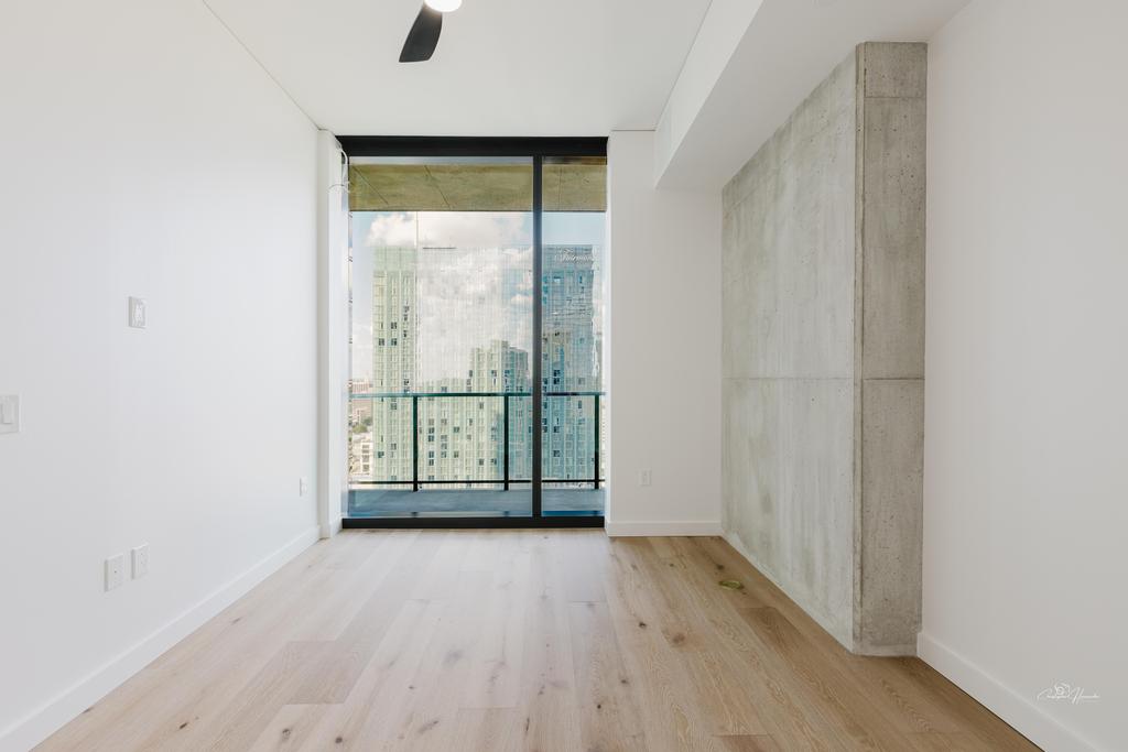 610 Davis Street, Unit 2608 Austin, TX 78701 - Photo 4 of 39 an empty room with wooden floor and windows