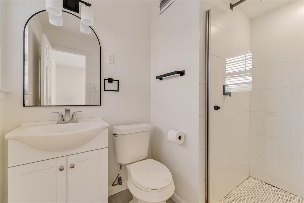 413 Simmons Drive Hurst, TX 76053 - Photo 14 of 26 a bathroom with a toilet sink and mirror