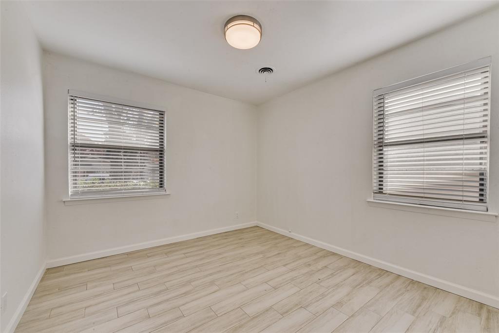 413 Simmons Drive Hurst, TX 76053 - Photo 17 of 26 a view of an empty room with wooden floor and a window