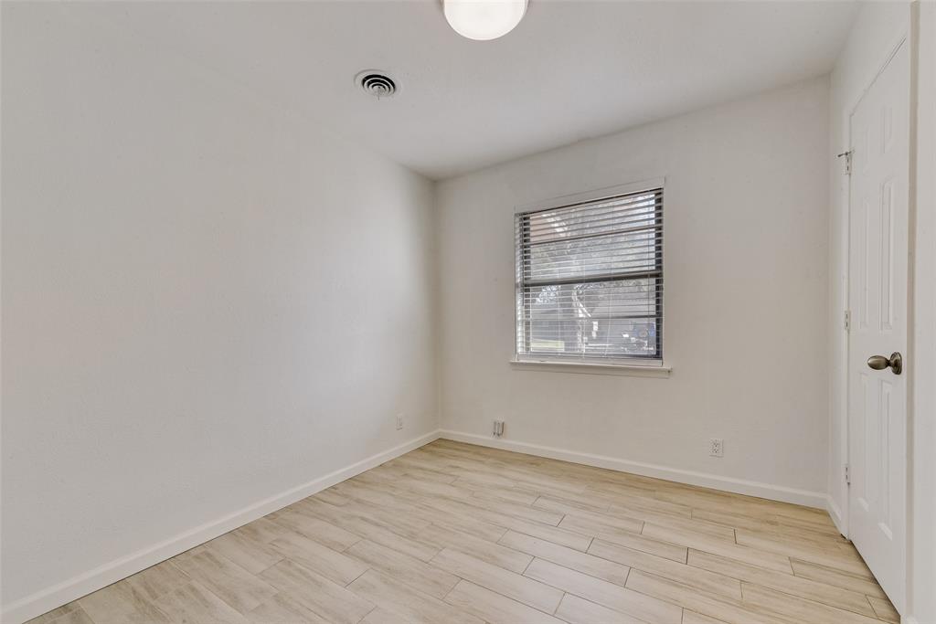 413 Simmons Drive Hurst, TX 76053 - Photo 18 of 26 a view of an empty room with wooden floor and a window