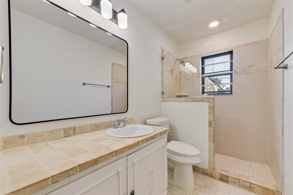 413 Simmons Drive Hurst, TX 76053 - Photo 19 of 26 a bathroom with a granite countertop sink toilet and mirror