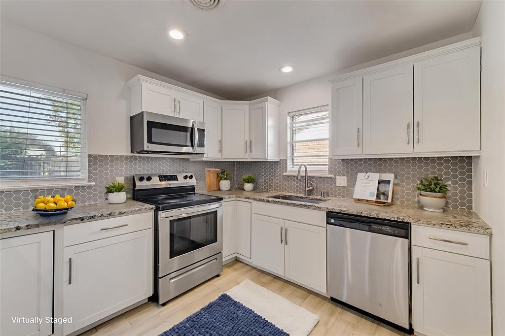 413 Simmons Drive Hurst, TX 76053 - Photo 4 of 26 a kitchen with stainless steel appliances granite countertop a stove a sink dishwasher and a microwave