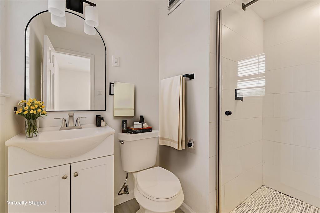 413 Simmons Drive Hurst, TX 76053 - Photo 7 of 26 a bathroom with a sink a toilet and shower