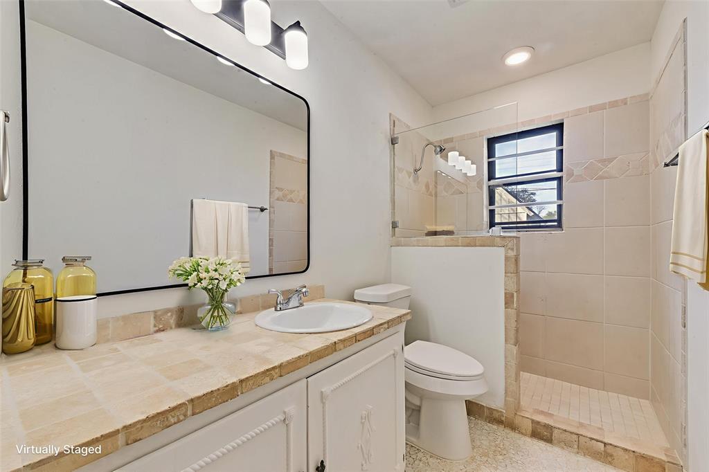 413 Simmons Drive Hurst, TX 76053 - Photo 9 of 26 a bathroom with a granite countertop sink toilet and mirror