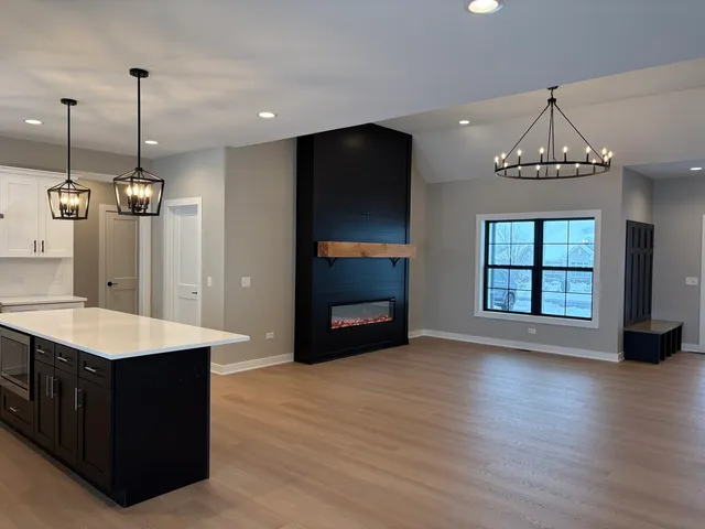 a view of an empty room with a kitchen and a fireplace