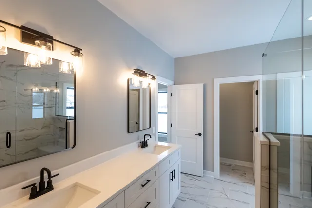 a bathroom with a double vanity sink mirror and shower