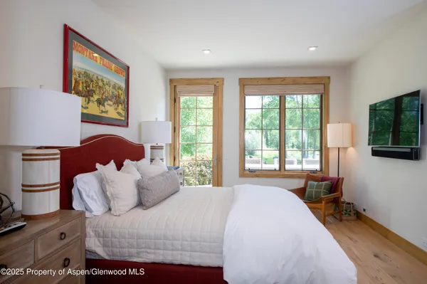 a bed room with a bed a television and a window