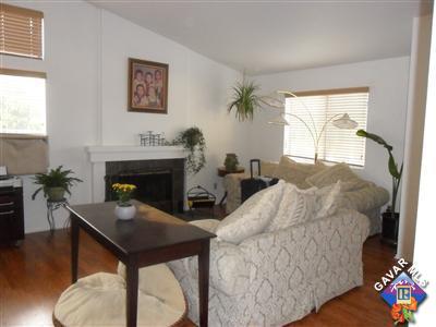 3248 Shale Road Palmdale, CA 93550 - Photo 4 of 19 a living room with furniture a flat screen tv and a fireplace