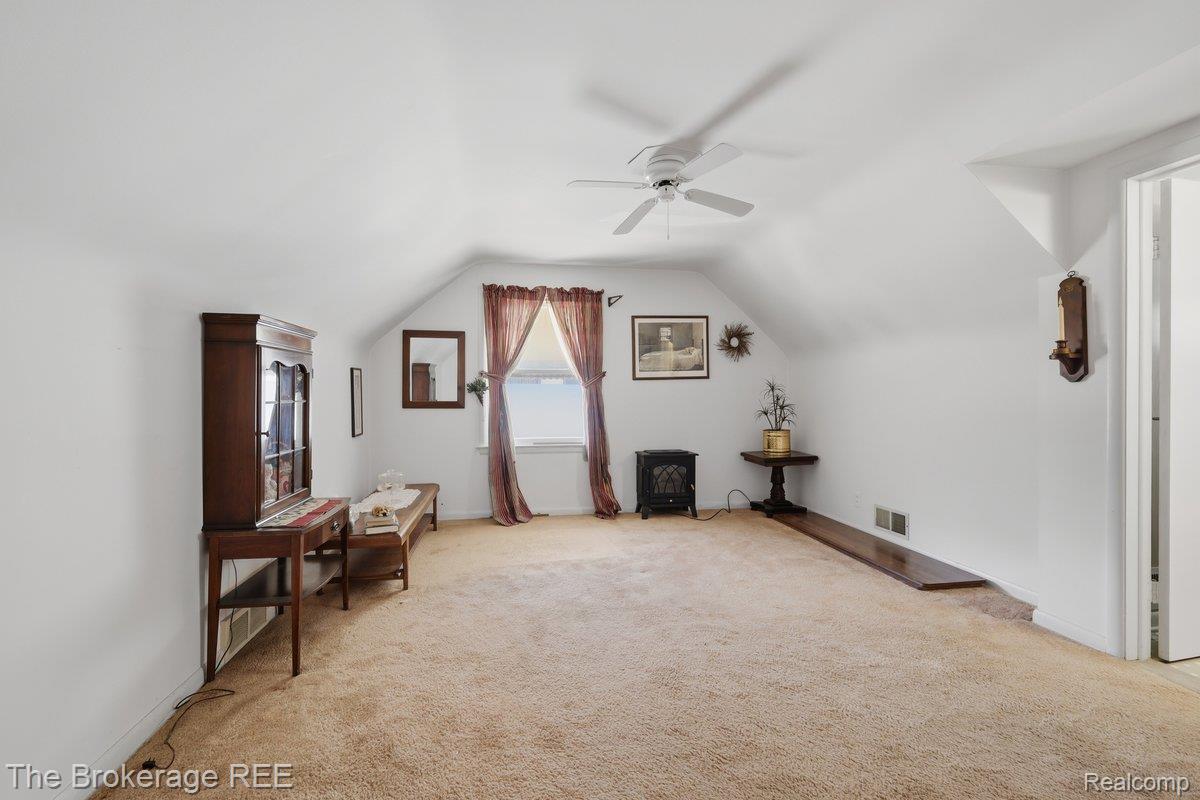 613 East Atherton Road Flint, MI 48507 - Photo 21 of 42 Sloped ceilings with a ceiling fan, carpet flooring, and a single window with curtain rods