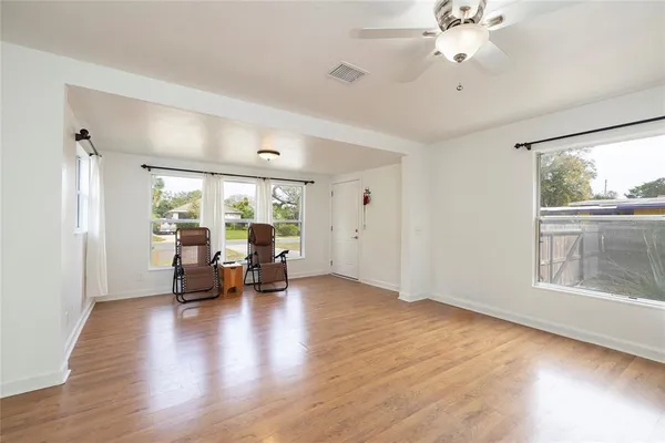 a view of a livingroom with furniture hardwood floor ceiling fan and window
