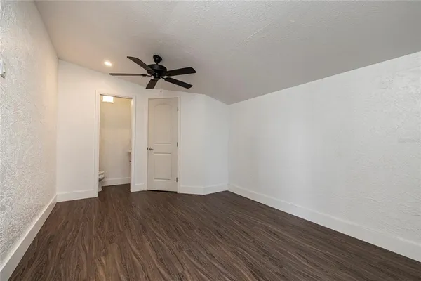 a view of empty room with wooden floor and ceiling fan