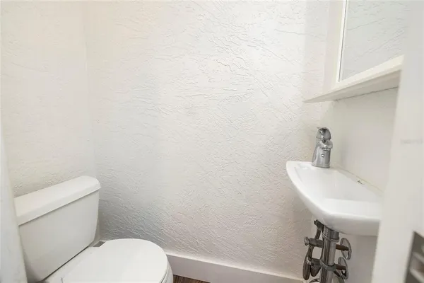 a bathroom with a sink a toilet and mirror