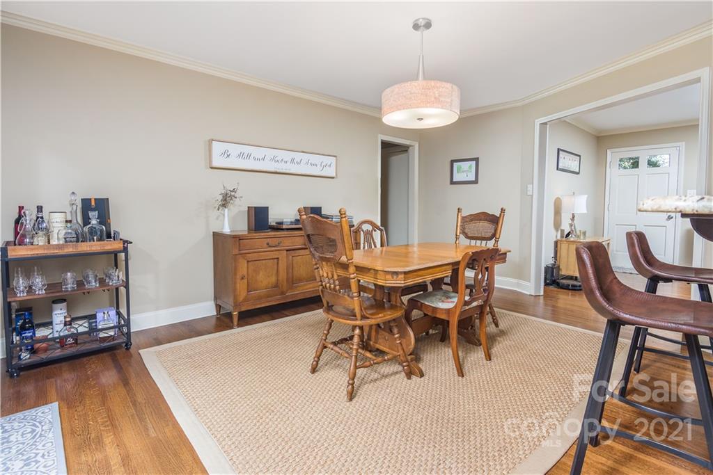 5201 Londonderry Road Charlotte, NC 28210 - Photo 11 of 42 a dining room with wooden floor a chandelier fan a wooden table and chairs