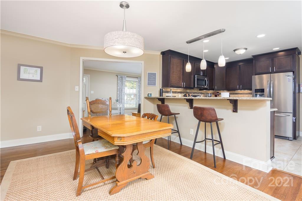 5201 Londonderry Road Charlotte, NC 28210 - Photo 13 of 42 a kitchen with stainless steel appliances kitchen island granite countertop a table chairs and a refrigerator