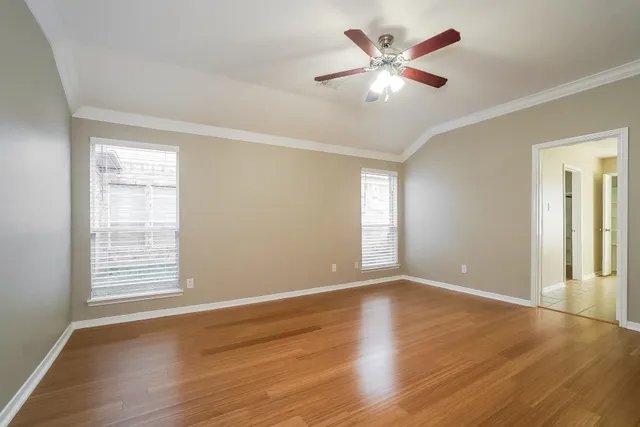 a view of an empty room with wooden floor