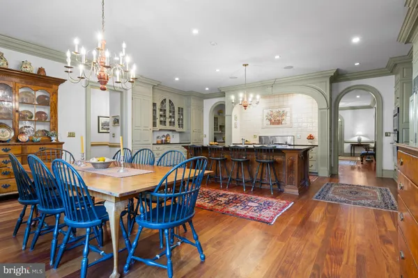 an open kitchen with granite countertop a stove a sink a dining table and chairs