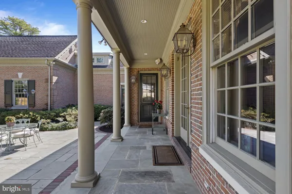 a view of swimming pool with seating space and trees in the background