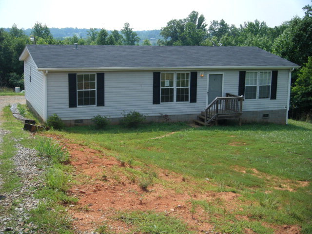 a front view of a house with a garden and yard