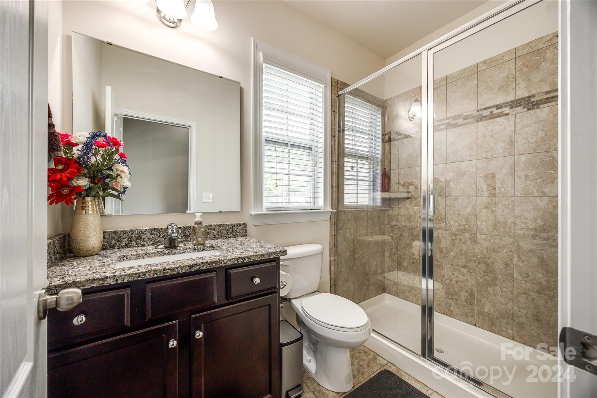 819 Bridge View Court Fort Mill, SC 29708 - Photo 16 of 40 a bathroom with a granite countertop sink toilet mirror and shower