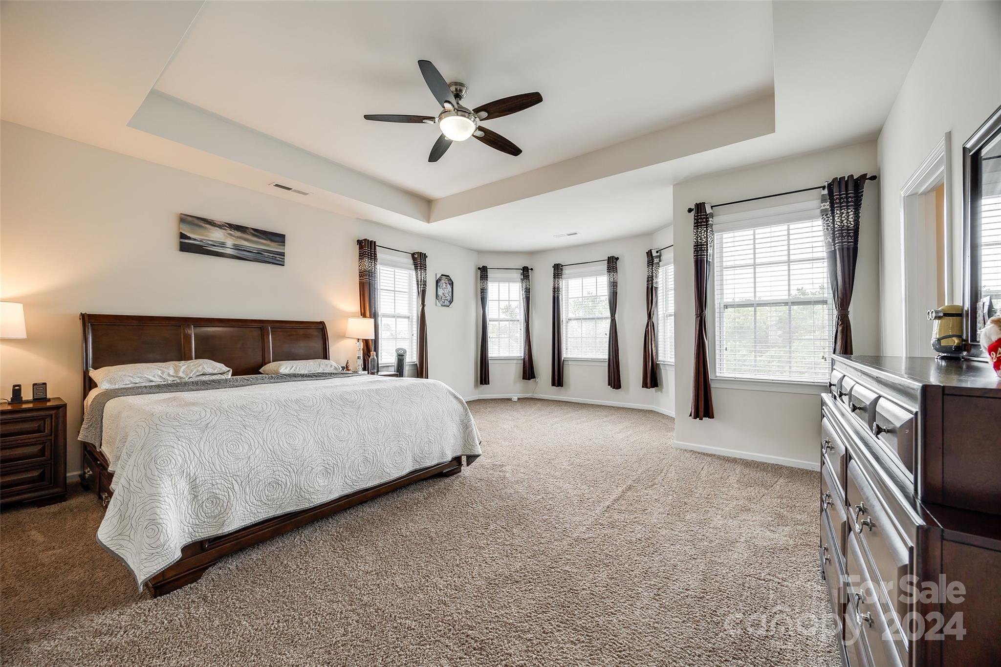 819 Bridge View Court Fort Mill, SC 29708 - Photo 18 of 40 a spacious bedroom with a large bed a flat screen tv and a dresser