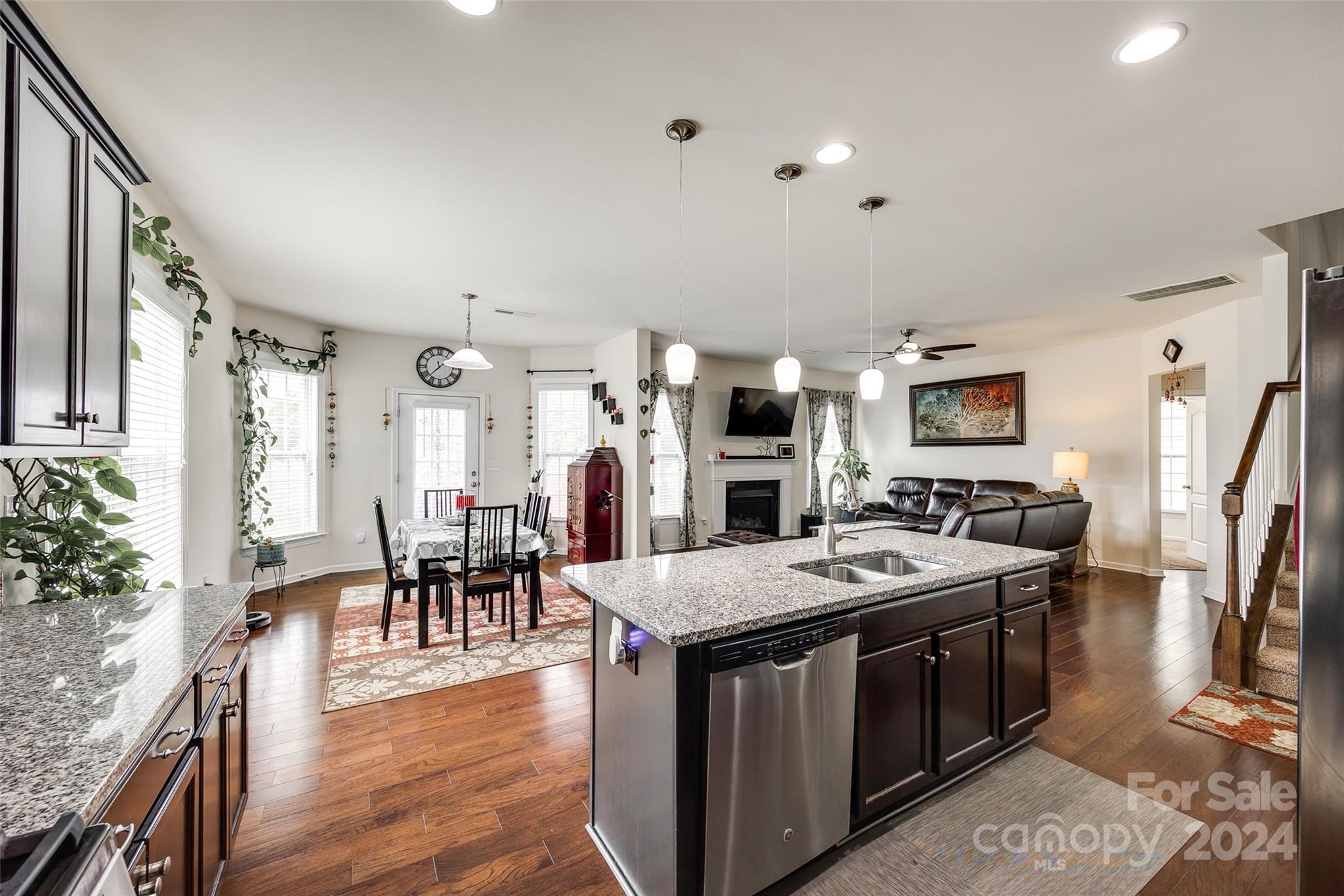 819 Bridge View Court Fort Mill, SC 29708 - Photo 8 of 40 a open kitchen with stainless steel appliances kitchen island granite countertop a table chairs and a refrigerator