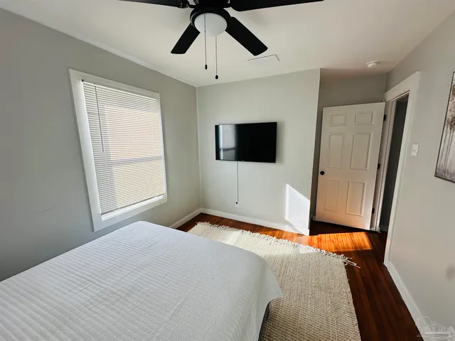 a bedroom with a bed and a flat tv screen on the dresser