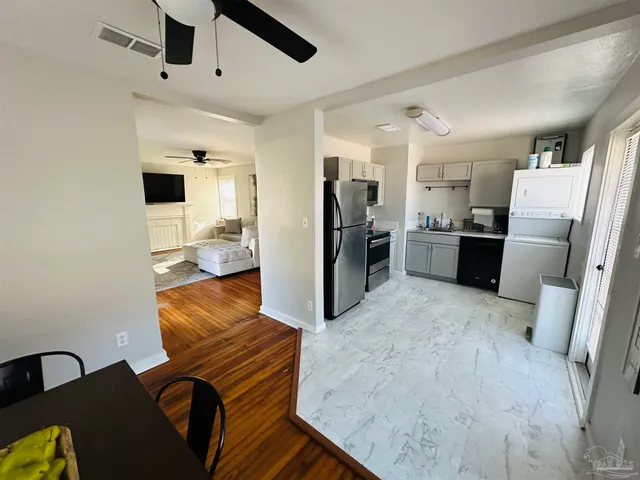 a kitchen with stainless steel appliances kitchen island granite countertop a refrigerator and a stove top oven