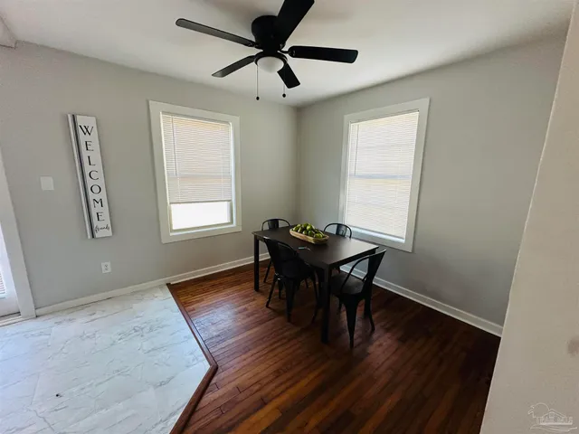 a view of a workspace room with wooden floor and a window