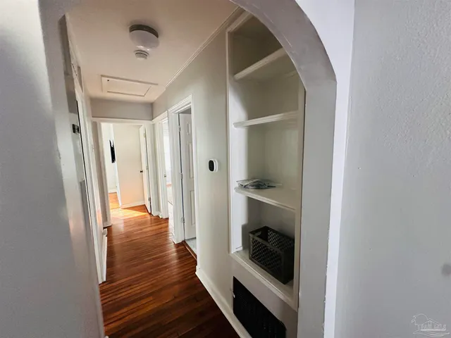 a view of a hallway with wooden floor and staircase