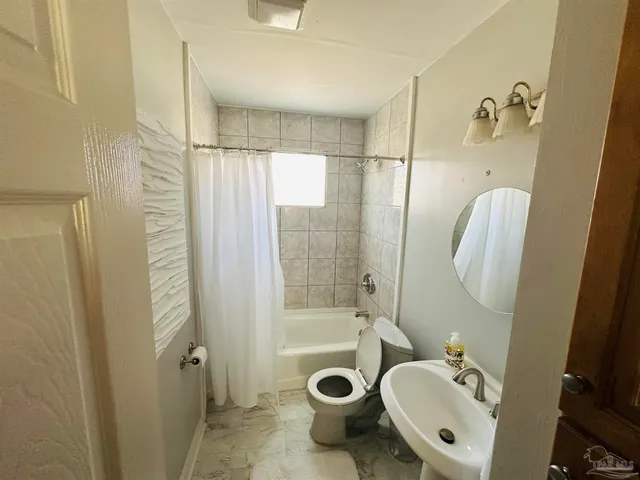 a bathroom with a sink a mirror a bathtub and shower