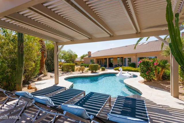 a view of swimming pool with outdoor seating and a patio
