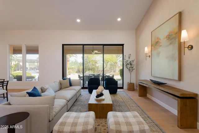 a living room with furniture and floor to ceiling windows