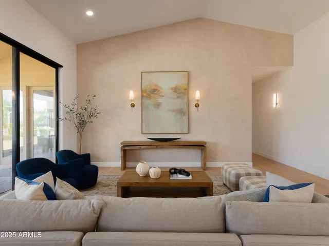 a living room with furniture and a large mirror