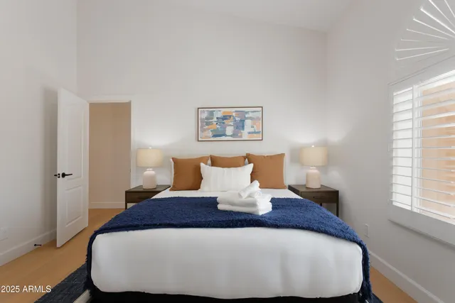 a large bed sitting in a bedroom next to a window