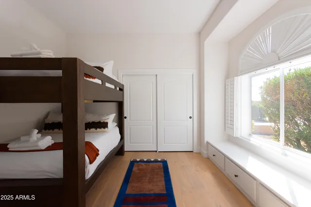 a bedroom with a bed and a large window