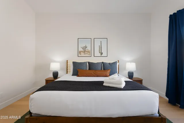 a bedroom with a bed and painting on the wall