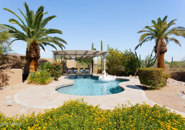 a view of a house with a swimming pool and sitting area