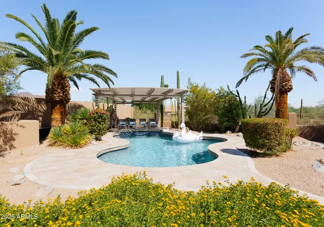 a view of a house with a swimming pool and sitting area