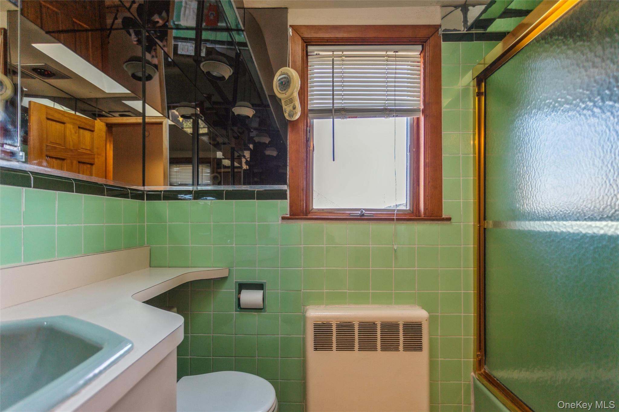 73 Parma Road Island Park, NY 11558 - Photo 21 of 37 a bathroom with a toilet sink and mirror