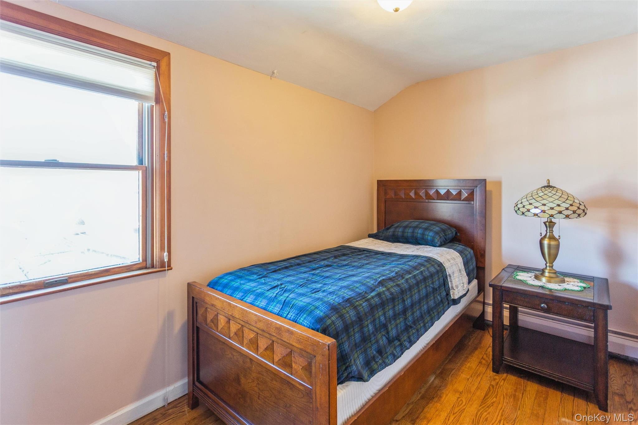 73 Parma Road Island Park, NY 11558 - Photo 22 of 37 a bed sitting in a bedroom next to a window