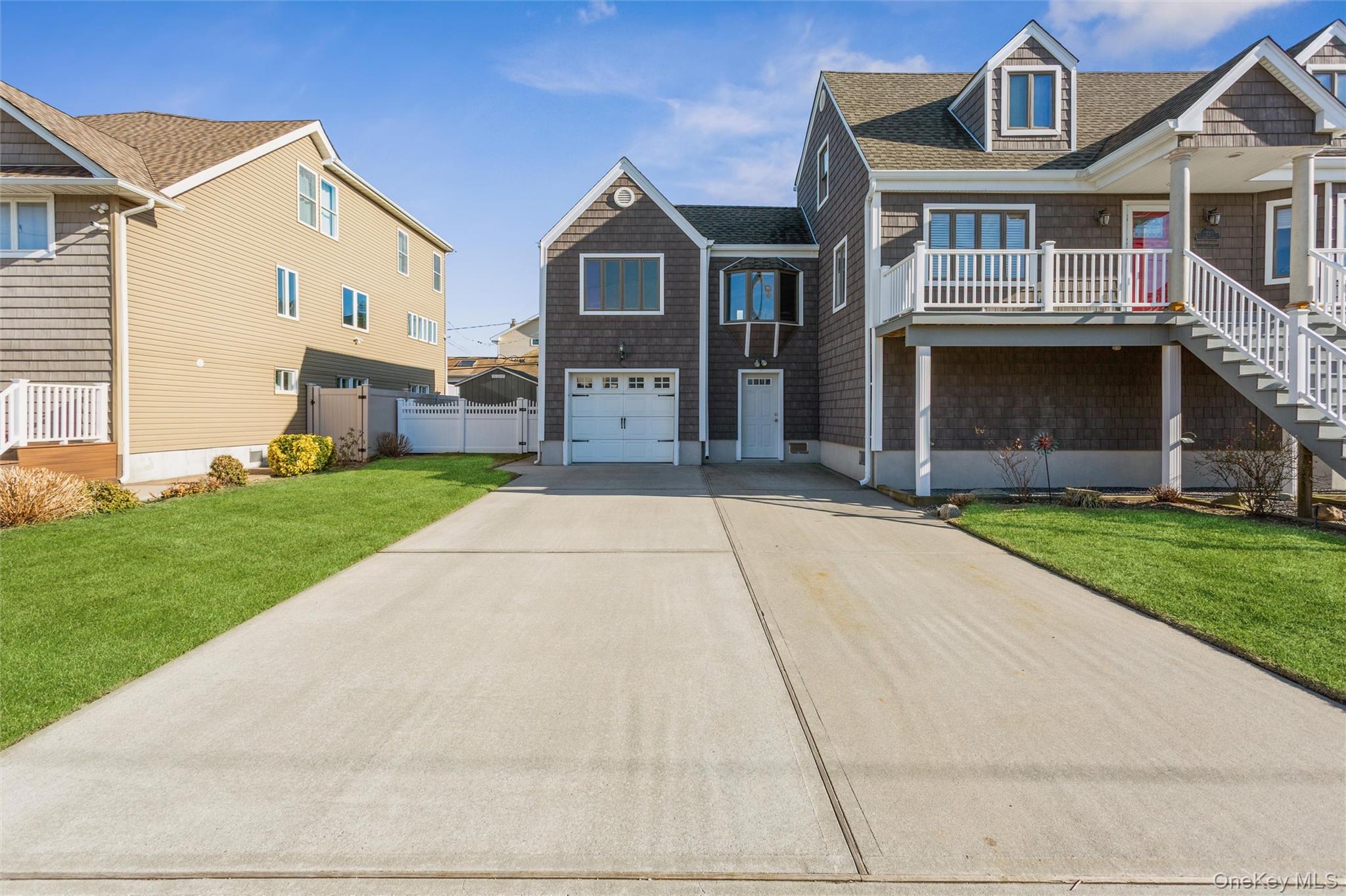 73 Parma Road Island Park, NY 11558 - Photo 28 of 37 a front view of a house with a yard and garage